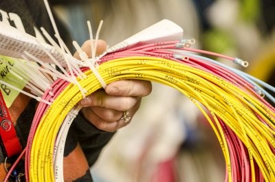 Close shot of a woman's hand holding several coils of electrical wiring.