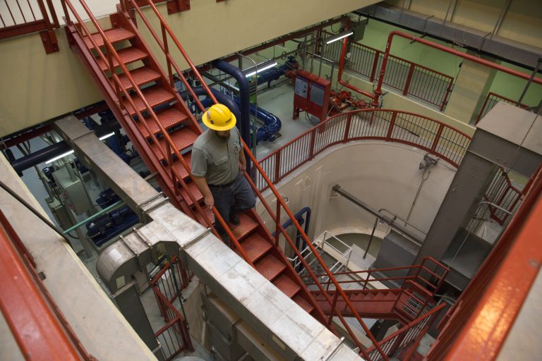 Man walking downstairs in an electrical area.